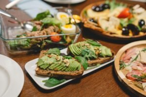 Close-up of an avocado toast and salad spread on a wooden table, perfect for a healthy meal.