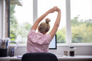 Office worker stretching to avoid the negative effects of sedentarism
