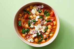 A bowl of chickpea and spinach stew garnished with herbs