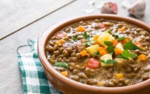 A bowl of hearty lentil and vegetable soup with fresh herbs
